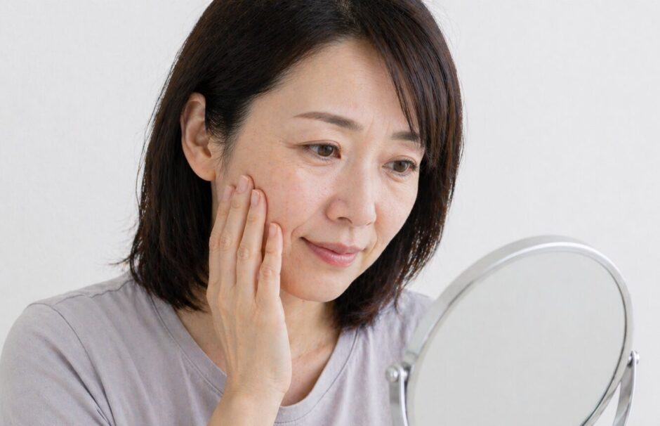 顔のしわ・たるみを気にして鏡を見る女性