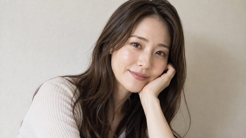 肘をついて微笑む女性