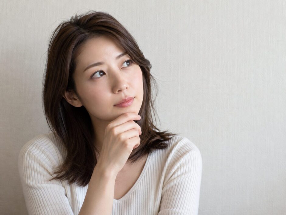 顎に手を当てて考える女性
